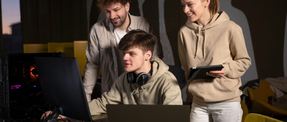 a group of friends standing together and using laptop