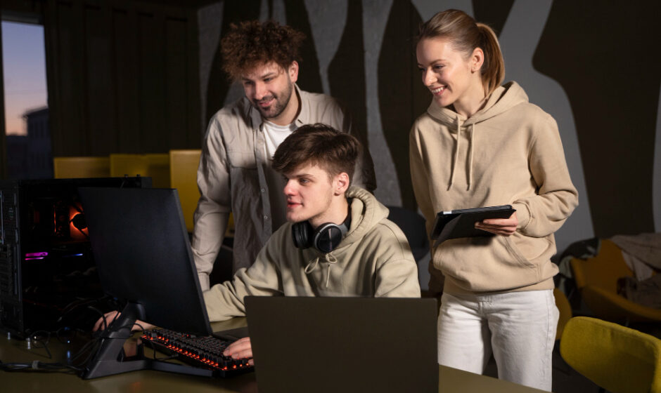 a group of friends standing together and using laptop