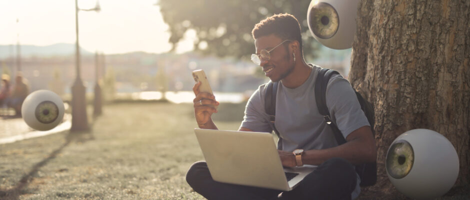 a guy sitting in a park and using satellite internet on his laptop