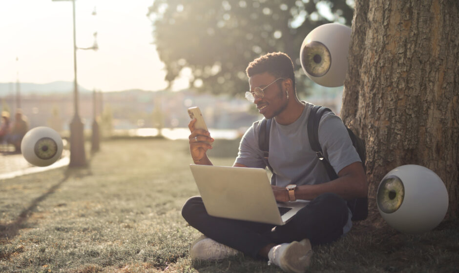 a guy sitting in a park and using satellite internet on his laptop