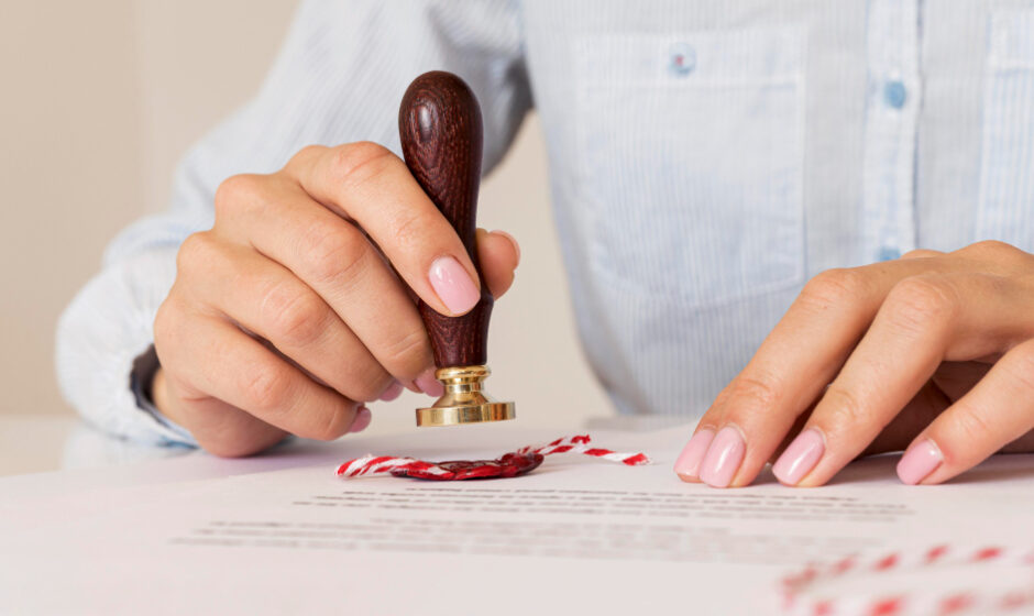 An individual applies a stamp to paper, representing trustworthy notarization and document services.