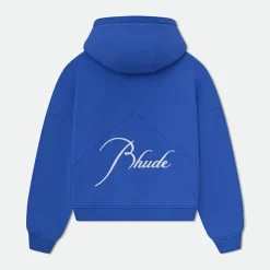 Rhude Clothing, founded by Rhuigi Villaseñor in 2015, has emerged as one of the most influential brands in luxury streetwear. The Los Angeles-based label seamlessly merges street culture with high fashion, making it a favorite among celebrities, influencers, and fashion enthusiasts worldwide. With its distinctive designs, premium quality, and bold aesthetics, Rhude has carved out a unique niche in contemporary menswear. The brand is synonymous with effortless cool, blending modern trends with nostalgic Americana influences. The Origins of Rhude Clothing Rhuigi Villaseñor, a Filipino-born designer, moved to the United States as a child and developed an early passion for fashion. His journey into the fashion world began with a deep appreciation for design, art, and street culture. Before founding Rhude, he gained experience working under renowned designers and honing his skills in garment construction. In 2015, he launched Rhude with a single product: a bandana-print T-shirt. This simple yet innovative piece caught the attention of fashion insiders and quickly became a sensation. Villaseñor’s vision for Rhude was clear from the beginning. He aimed to create a brand that fused casual streetwear with elements of luxury, giving consumers high-end designs with a relaxed, wearable feel. This balance between sophistication and street appeal became the foundation of Rhude Clothing’s identity. Signature Aesthetic and Design Philosophy Rhude Clothing is known for its bold, edgy aesthetic that incorporates vintage inspirations, oversized silhouettes, and a muted color palette. The brand often blends luxury tailoring with rugged streetwear elements, making it a go-to choice for those who want both comfort and style. One of Rhude’s most recognizable design elements is the use of graphic prints and unique patterns. The bandana motif, seen in many collections, has become an iconic symbol of the brand. Additionally, Rhude frequently incorporates deconstructed and distressed fabrics, adding to its raw, rebellious feel. Despite its streetwear roots, Rhude is deeply influenced by classic menswear and luxury fashion. Villaseñor often draws inspiration from vintage Americana, automotive culture, and European tailoring. This mix of high and low fashion results in pieces that feel both nostalgic and forward-thinking. The Celebrity Factor: Rhude’s Global Reach Rhude has gained massive popularity thanks in part to its celebrity endorsements. High-profile figures like LeBron James, Jay-Z, A$AP Rocky, and Justin Bieber have been spotted wearing Rhude Clothing. These celebrity co-signs have played a significant role in boosting the brand’s visibility and appeal. The brand’s presence on social media and in pop culture has also contributed to its rapid growth. With frequent collaborations and limited-edition drops, Rhude has mastered the art of hype. Fashion lovers eagerly anticipate new releases, often leading to sold-out collections within minutes. Rhude Collaborations: Expanding Influence Collaboration has been a key strategy in Rhude’s success. Over the years, the brand has partnered with major names in the fashion, automotive, and sports industries. Some of the most notable collaborations include: Puma x Rhude: A multi-season partnership that blends Puma’s sportswear expertise with Rhude’s luxury streetwear aesthetic. The collection features sneakers, apparel, and accessories that reflect Villaseñor’s signature design style. Lamborghini x Rhude: A collaboration celebrating speed, performance, and luxury. This collection includes racing-inspired pieces that merge automotive culture with high fashion. McLaren x Rhude: Another automotive-inspired collection that fuses motorsport heritage with modern streetwear elements. Zara x Rhude: A more accessible collaboration that brings Rhude’s aesthetic to a wider audience through the global fast-fashion giant. These collaborations have not only expanded Rhude’s reach but also solidified its status as a cultural powerhouse. The Evolution of Rhude: From Streetwear to Luxury Fashion What sets Rhude apart from many other streetwear brands is its seamless transition into the luxury fashion space. While it started with T-shirts and hoodies, the brand has evolved to include high-end tailoring, leather goods, and footwear. Today, Rhude is stocked in prestigious retailers such as SSENSE, Saks Fifth Avenue, and Neiman Marcus, placing it among some of the most respected names in fashion. Rhude’s price point reflects its position in the luxury market. A standard T-shirt can range from $200 to $400, while jackets and outerwear can reach well into the thousands. Despite the high prices, demand remains strong due to the brand’s exclusivity and reputation for quality craftsmanship. The Future of Rhude Clothing As Rhude continues to grow, its influence in both streetwear and high fashion is expected to expand. Villaseñor has expressed his ambition to turn Rhude into a full-fledged luxury house, similar to brands like Off-White and Fear of God. With a strong brand identity and a loyal fan base, Rhude is well on its way to achieving that goal. The brand has also hinted at further expansion into womenswear, accessories, and even lifestyle products. As the boundaries between streetwear and luxury continue to blur, Rhude remains at the forefront of this evolving fashion landscape. Conclusion Rhude Clothing has redefined modern luxury streetwear by blending bold aesthetics, high-quality craftsmanship, and cultural influences. From its humble beginnings with a single T-shirt to its status as a globally recognized brand, Rhude’s journey is a testament to creativity and innovation. With an ever-growing list of celebrity endorsements, high-profile collaborations, and a clear vision for the future, Rhude is set to remain a powerhouse in contemporary fashion.